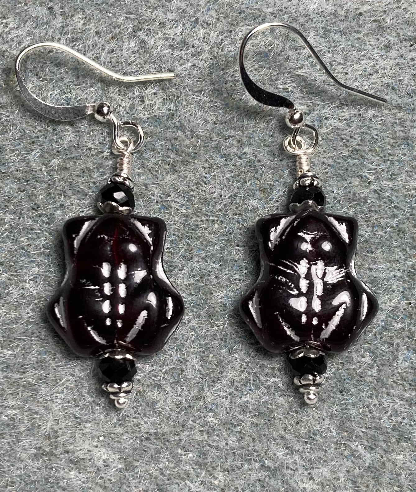 Black (with silver inlay) Czech glass turtle bead earrings adorned with black Chinese crystal beads.