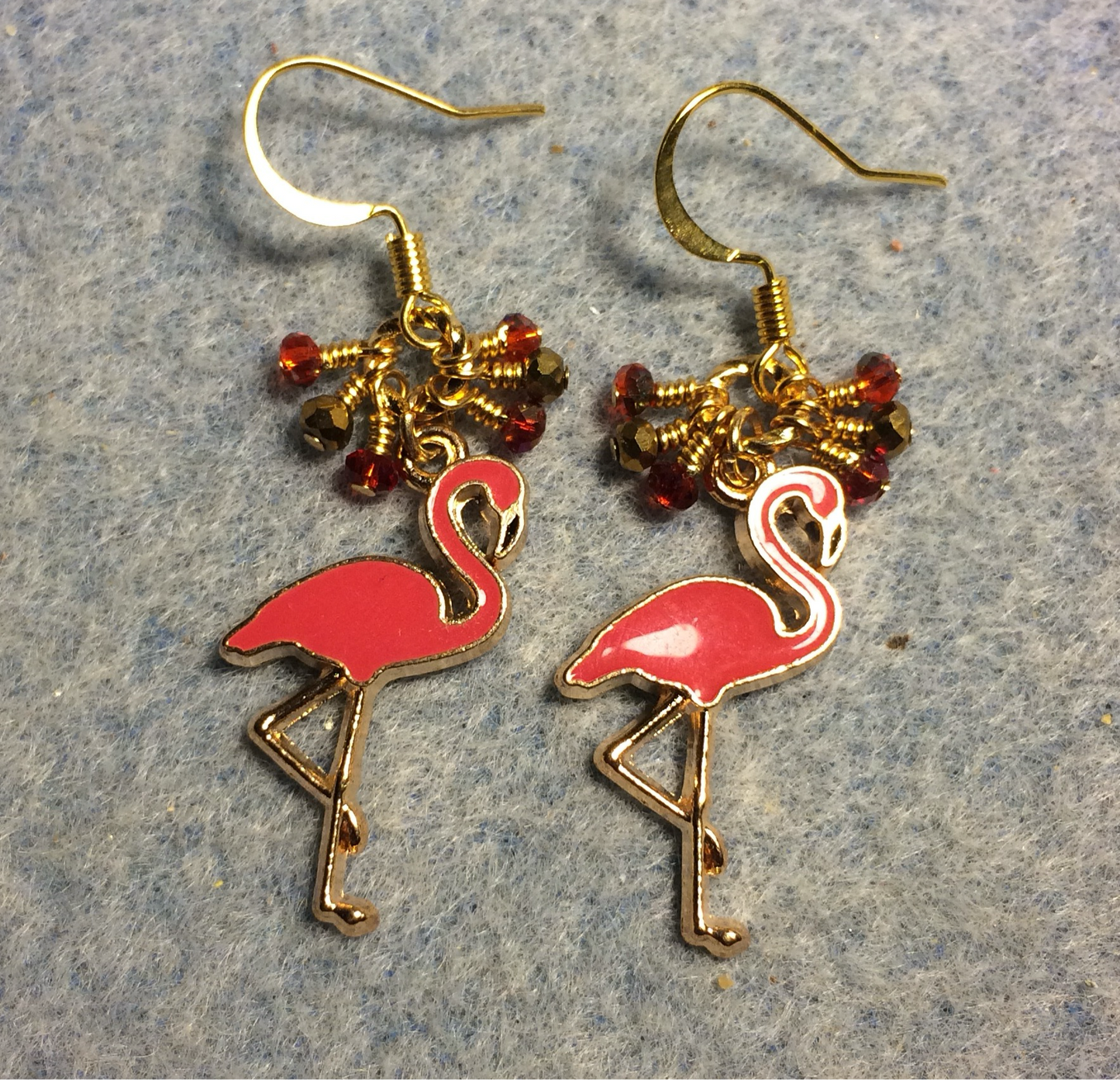 Reddish pink enamel flamingo charm earrings adorned with tiny dangling red and gold Chinese crystal beads.