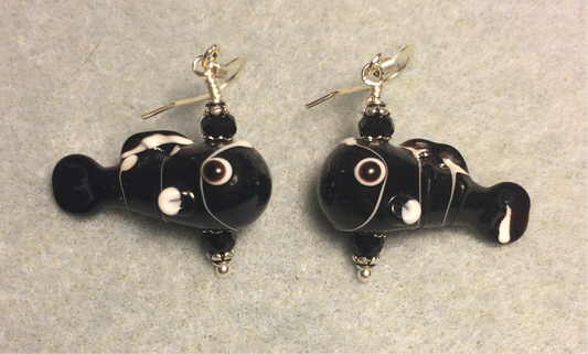 Black and white lamp work fish bead earrings adorned with black Chinese crystal beads.