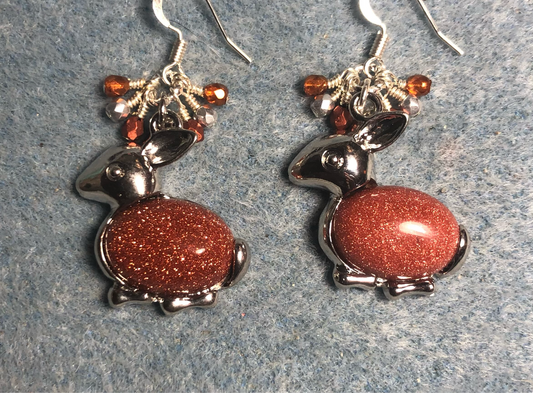 Large silver and orange goldstone gemstone rabbit charm earrings adorned with small dangling orange and silver Czech glass beads.