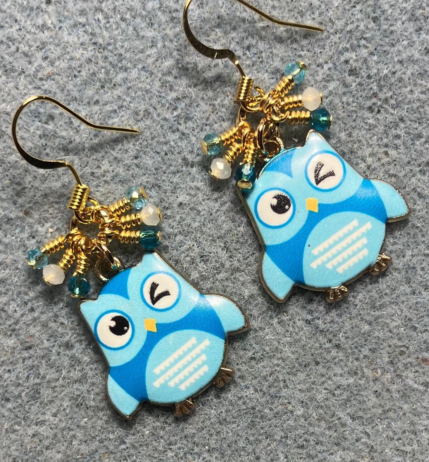 Turquoise and white enamel owl charm earrings adorned with tiny dangling dark turquoise, light turquoise, and white Chinese crystal beads.