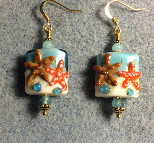 Light aqua, brown, and orange lamp work starfish bead earrings adorned with light aqua Czech glass beads.