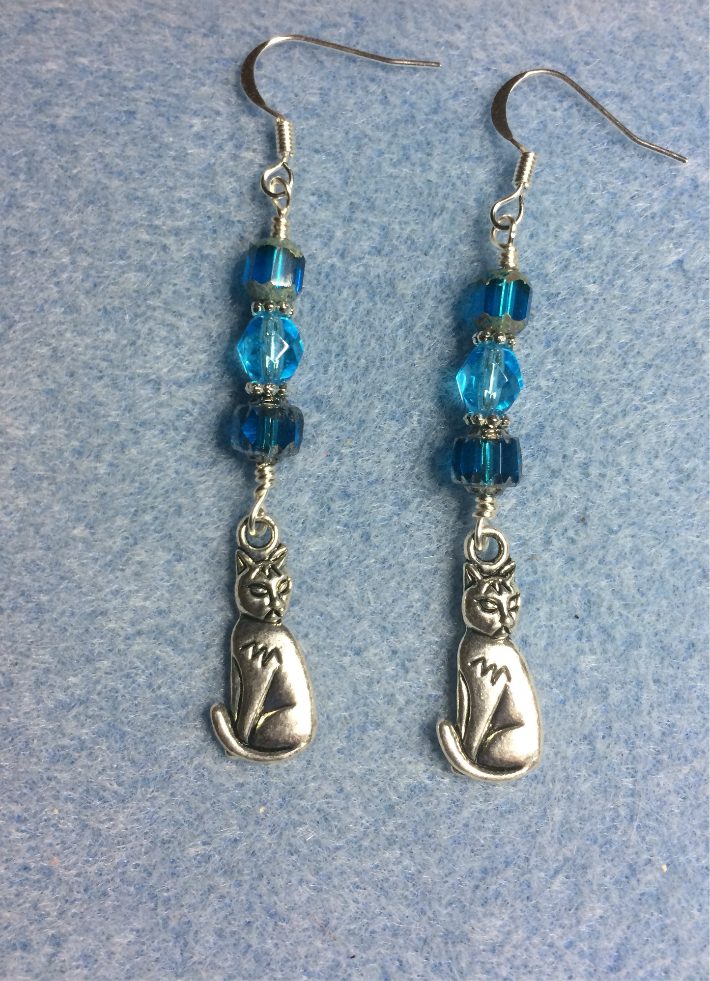 Silver cat charm earrings adorned with turquoise Czech glass beads
