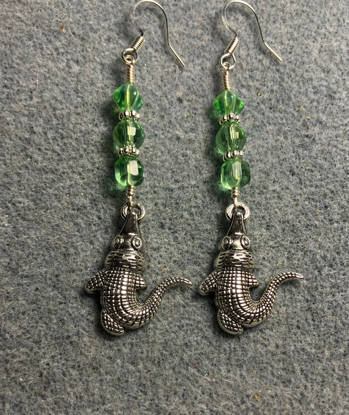 Silver alligator charm earrings adorned with light green Czech glass beads