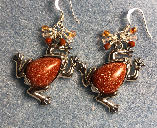 Large silver and orange goldstone gemstone frog charm earrings adorned with small dangling orange and clear Czech glass beads.