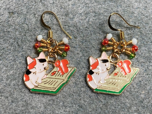 Orange, white, and black enamel calico cat charm earrings adorned with tiny dangling orange, white, and green Chinese crystal beads.