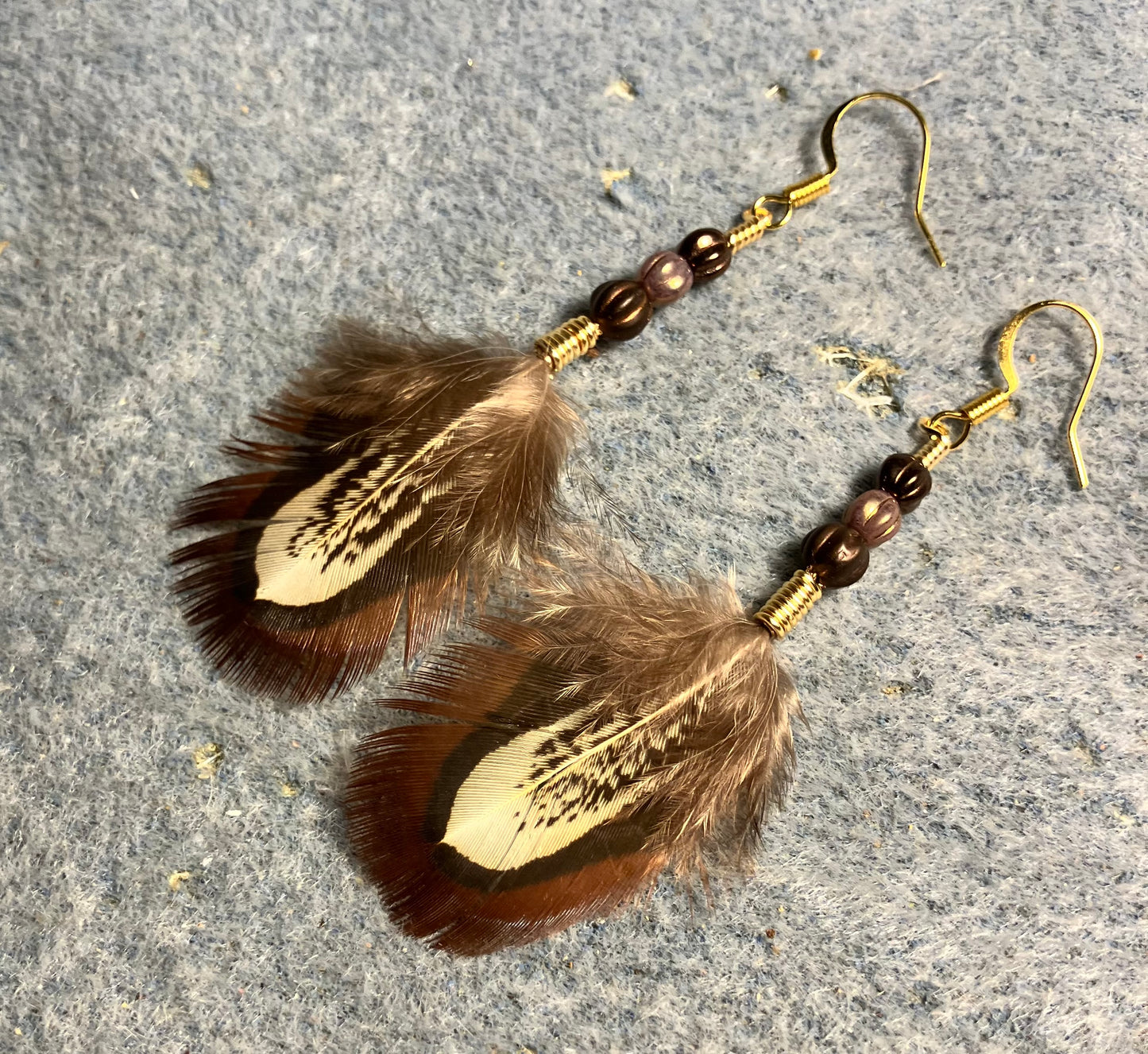 Brown ringneck pheasant feather earrings adorned with brown and tan Czech glass beads.