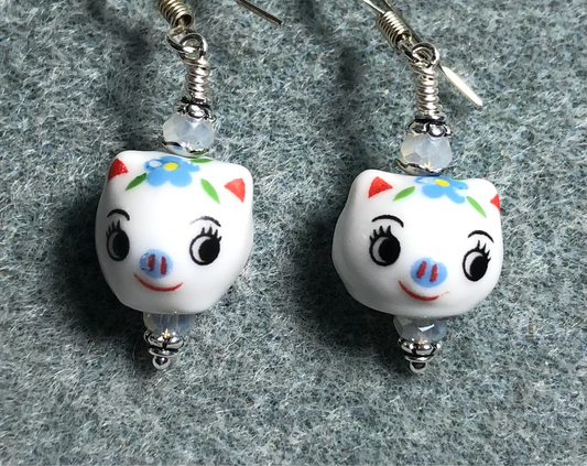 Small white, blue, and black ceramic pig bead earrings adorned with white Chinese crystal beads.