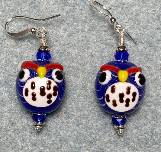 Blue and white lamp work spotted owl bead earrings adorned with dark blue Chinese crystal beads.