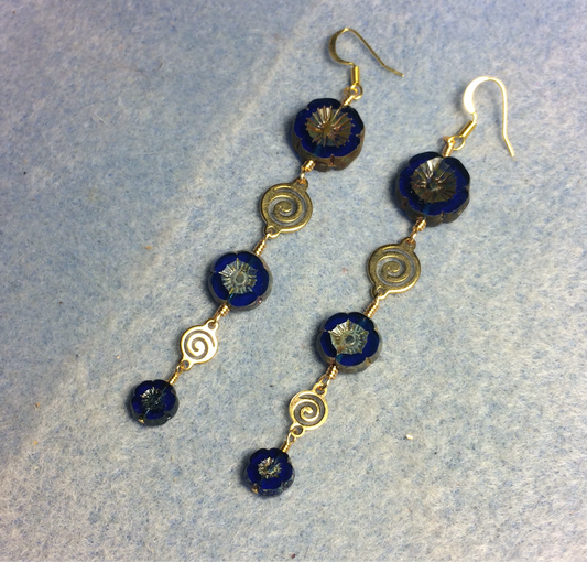 Extra long blue flower bead earrings made with three sizes of cobalt blue Czech glass pansy beads joined by gold swirly connectors.