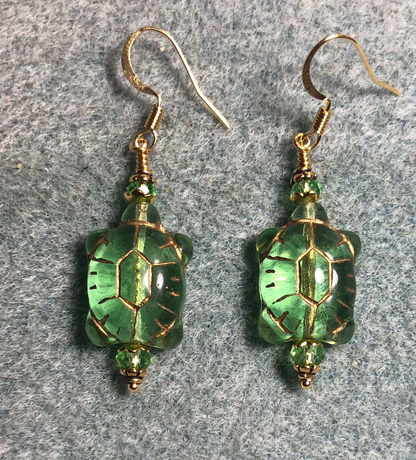 Peridot green (with gold inlay) Czech glass turtle bead earrings adorned with light green Chinese crystal beads.