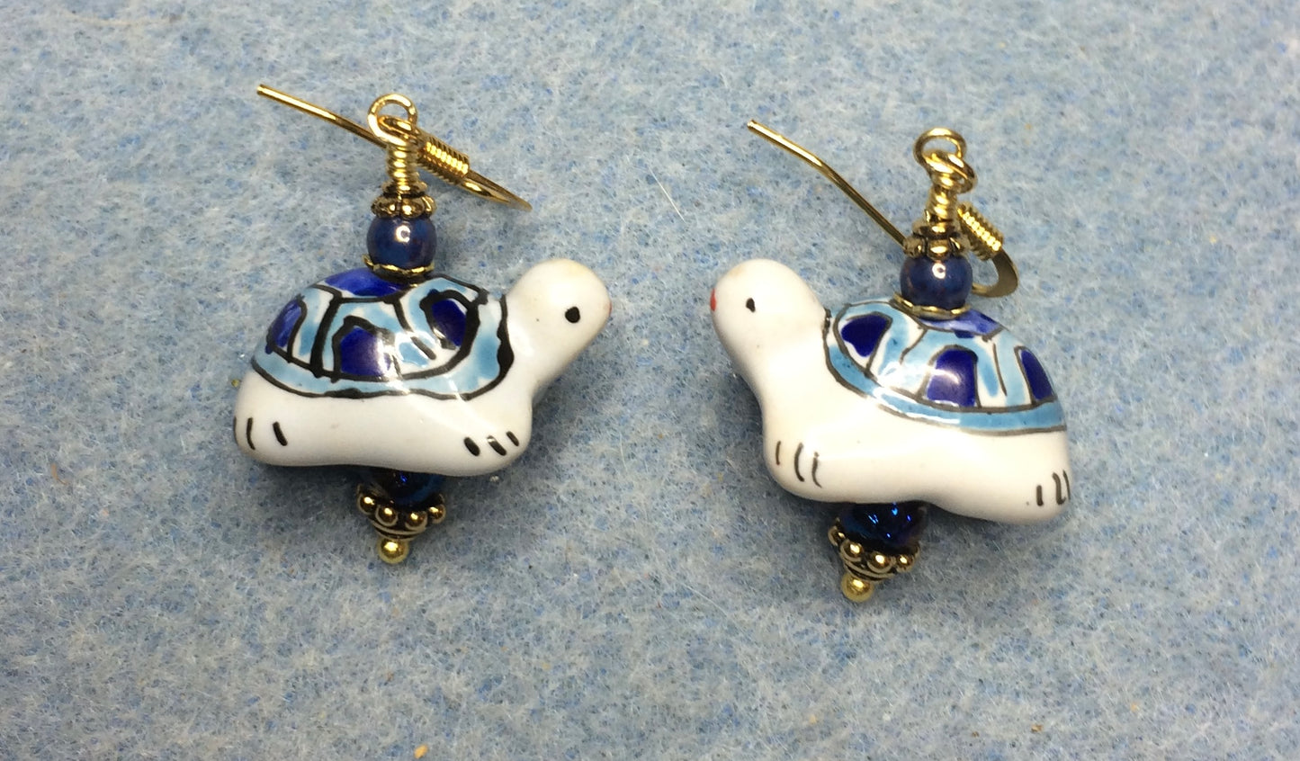 Blue and white ceramic turtle bead earrings adorned with blue Czech glass beads.