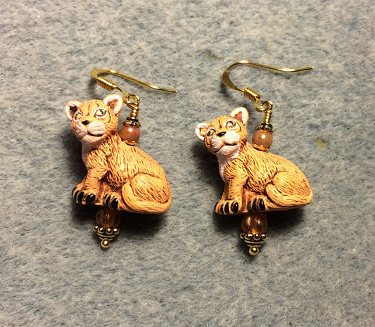 Orange ceramic lion cub bead earrings adorned with orange Czech glass beads.
