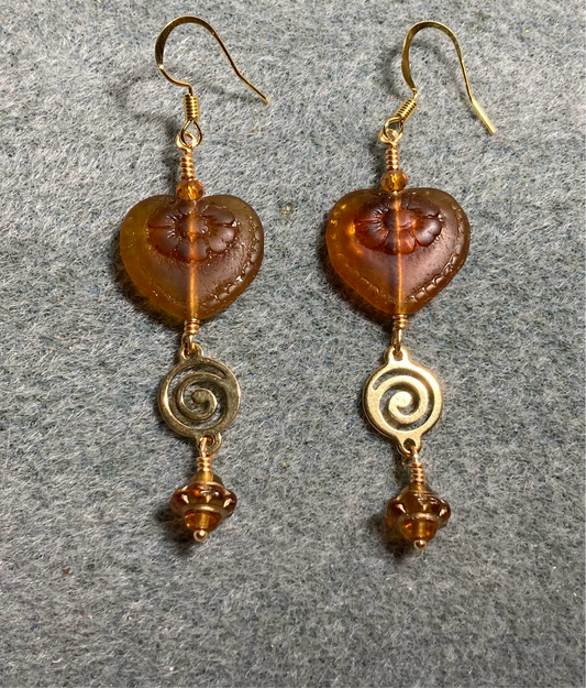 Dark topaz Czech glass heart bead earrings adorned with gold swirly links and topaz Czech glass Saturn beads.