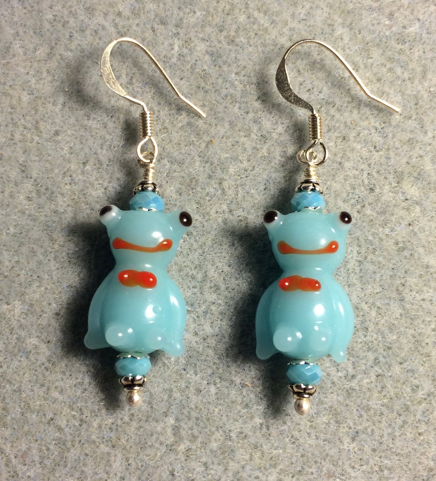 Opaque light aqua lamp work silly frog bead earrings adorned with aqua Chinese crystal beads.