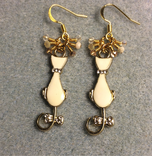 Off white and gold enamel cat charm earrings adorned with tiny dangling off white and gold Chinese crystal beads.
