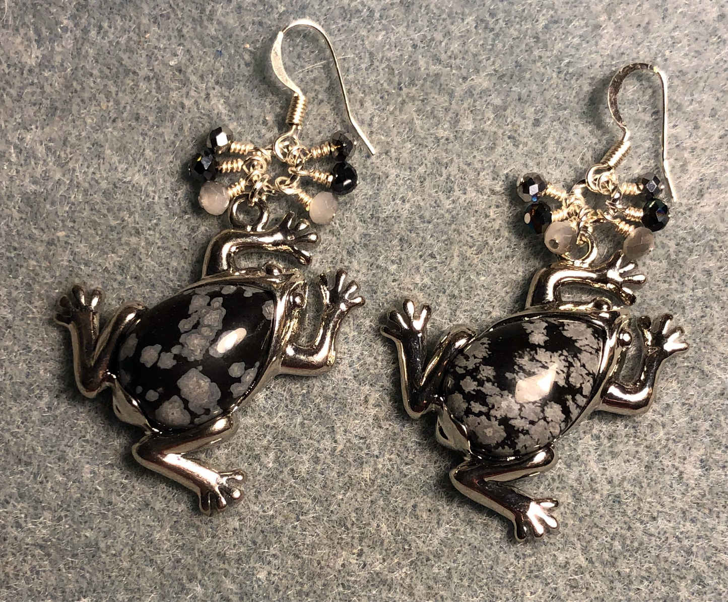 Large silver and snow jasper gemstone frog charm earrings adorned with small dangling gray, black, and white Chinese crystal beads.