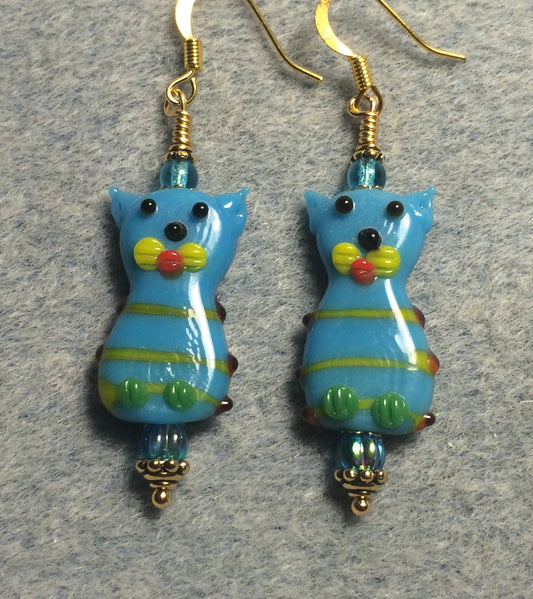 Turquoise, yellow, and green lamp work cat bead earrings adorned with turquoise Czech glass beads.