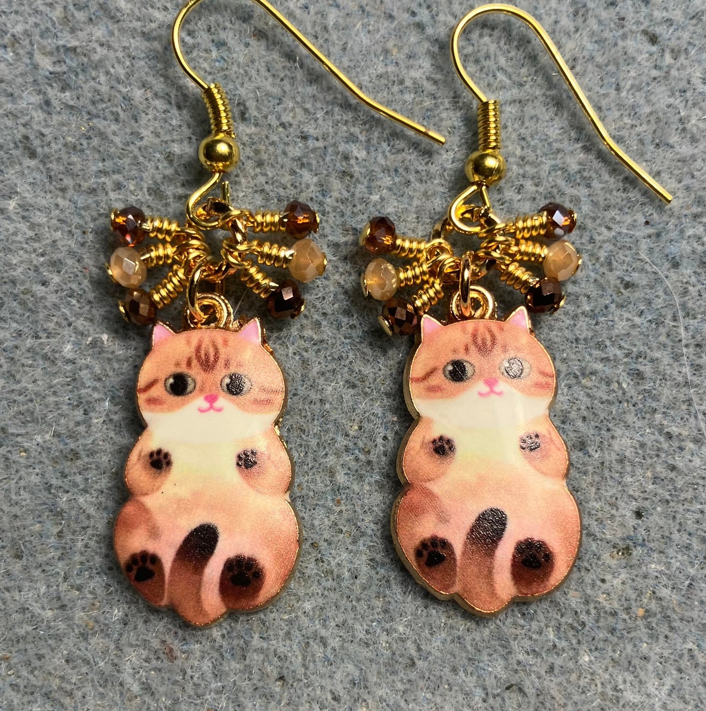 Brown and tan enamel cat charm earrings adorned with tiny dangling brown, tan, and amber Chinese crystal beads.