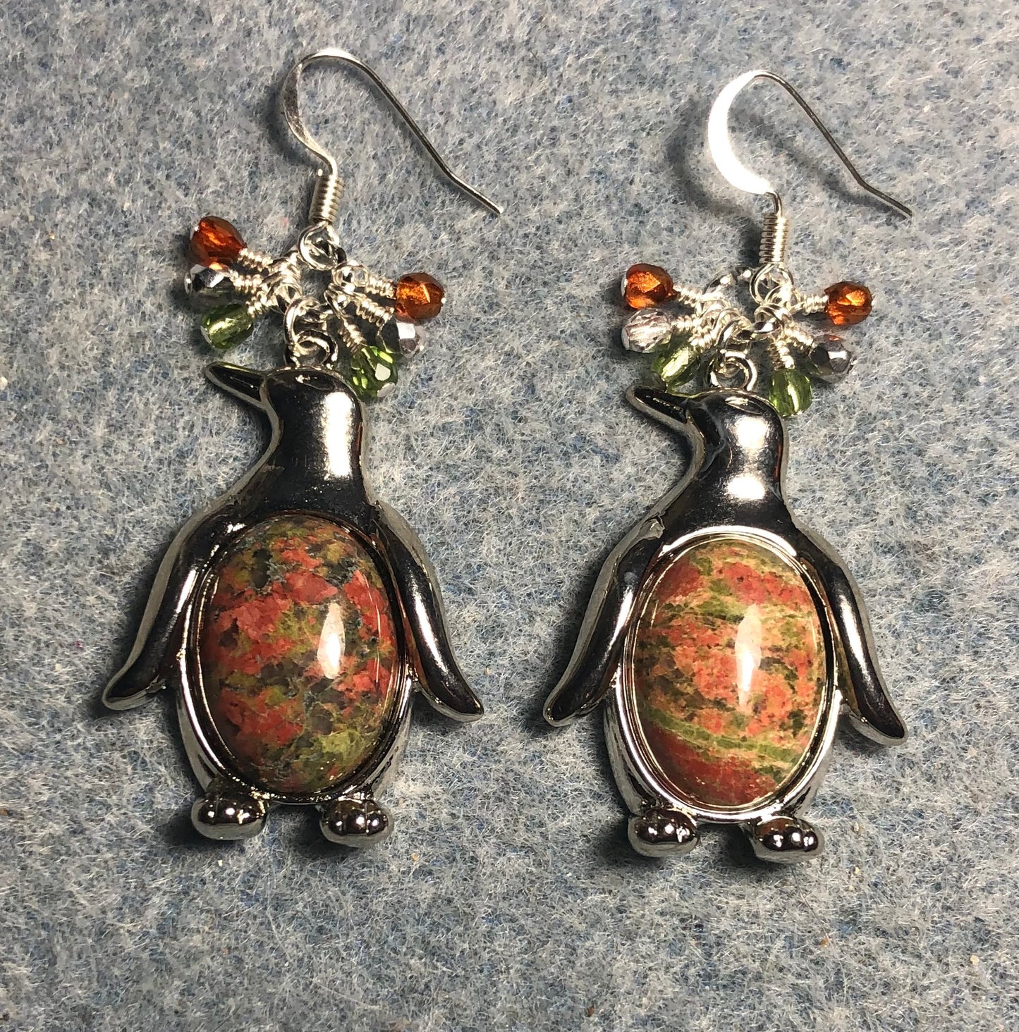 Large silver and unakite gemstone penguin charm earrings adorned with small dangling orange and green Czech glass beads.