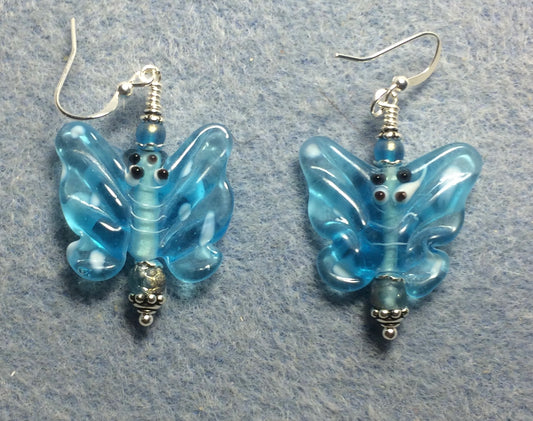 Light turquoise lamp work butterfly bead earrings adorned with light turquoise Czech glass beads.