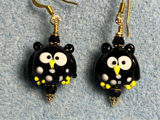 Black, white, and yellow lamp work spotted owl bead earrings adorned with black Chinese crystal beads.