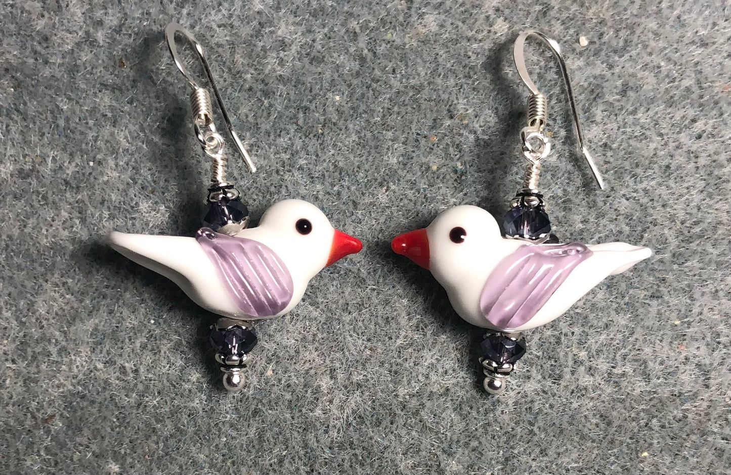 Opaque white and lavender lamp work songbird bead earrings adorned with lavender Chinese crystal beads.