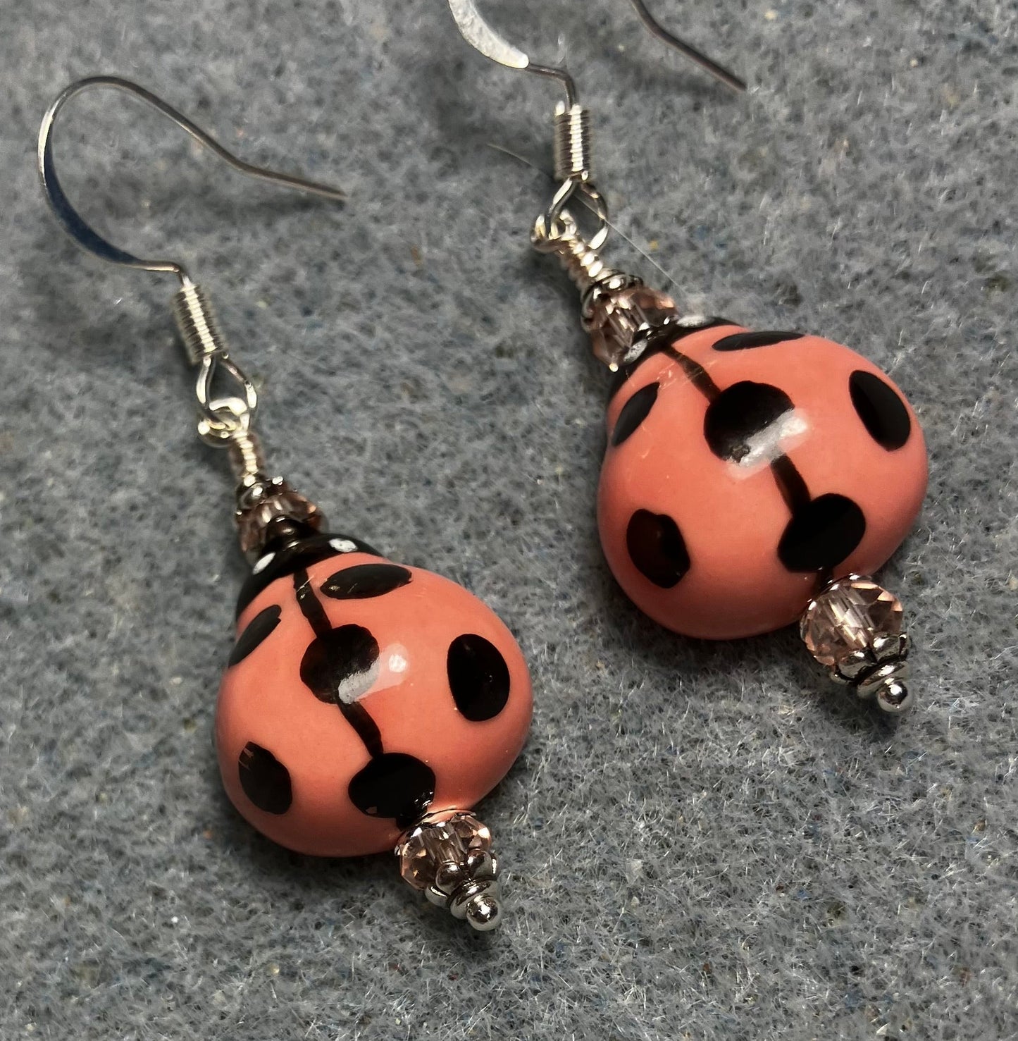 Coral pink and black ceramic ladybug bead earrings adorned with coral pink Chinese crystal beads.