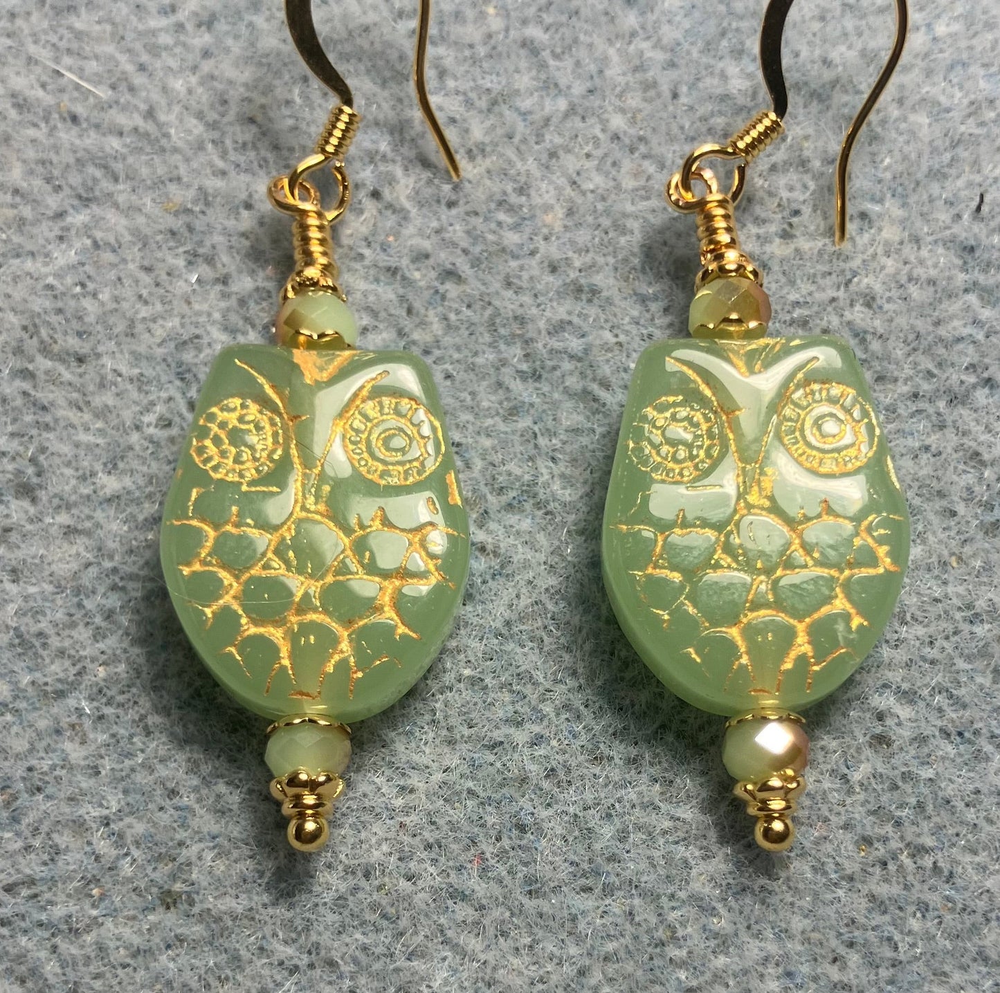 Light green (with gold wash) Czech glass owl bead earrings adorned with light green Chinese crystal beads.