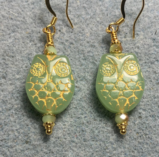 Light green (with gold wash) Czech glass owl bead earrings adorned with light green Chinese crystal beads.