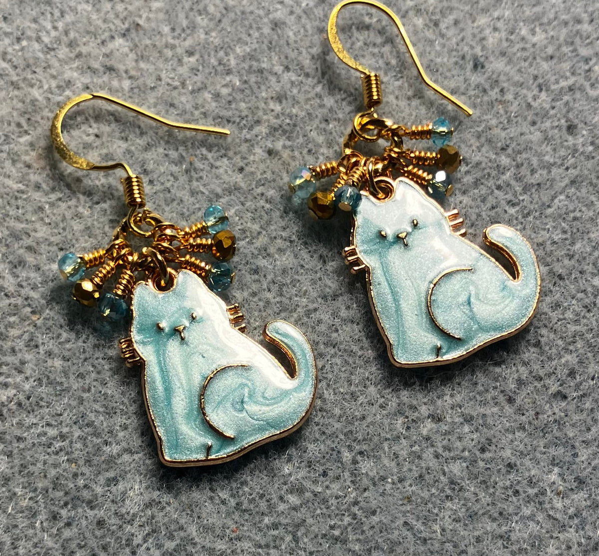 Turquoise and gold enamel cat charm earrings adorned with tiny dangling turquoise and gold Chinese crystal beads.