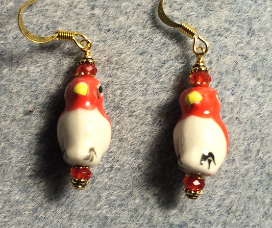 Red and white ceramic penguin bead earrings adorned with red Chinese crystal beads.