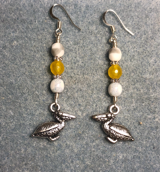 Silver pelican charm earrings adorned with white gray and yellow Czech glass beads