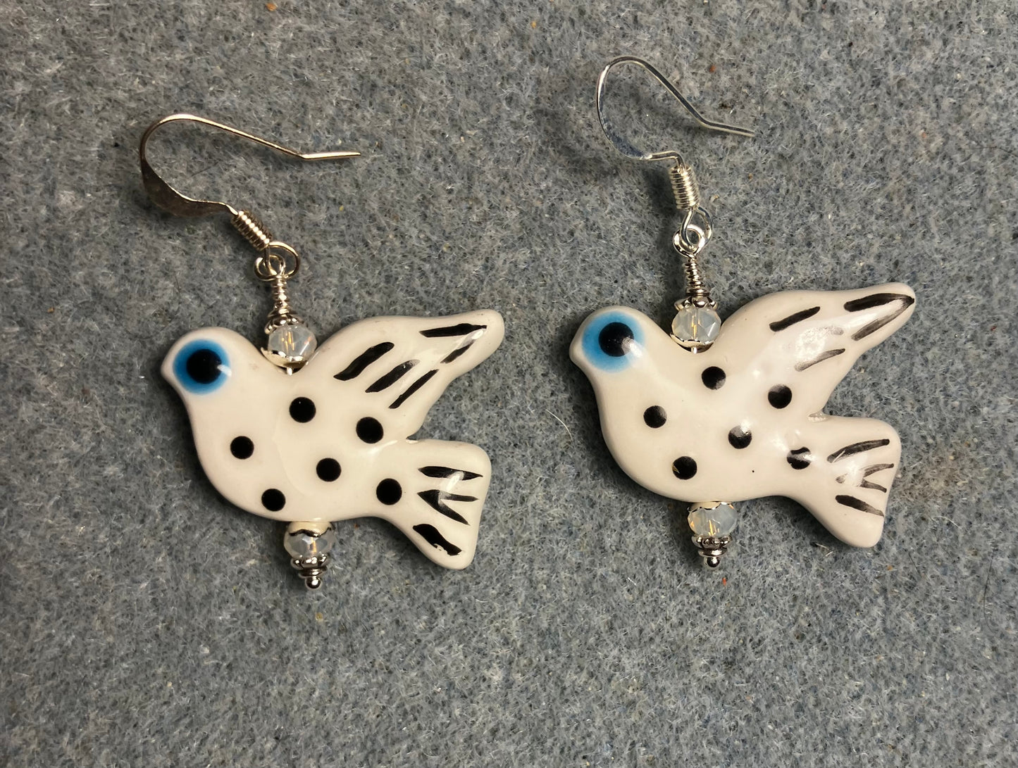 Large white, black, and turquoise ceramic spotted dove bead earrings adorned with white Chinese crystal beads.