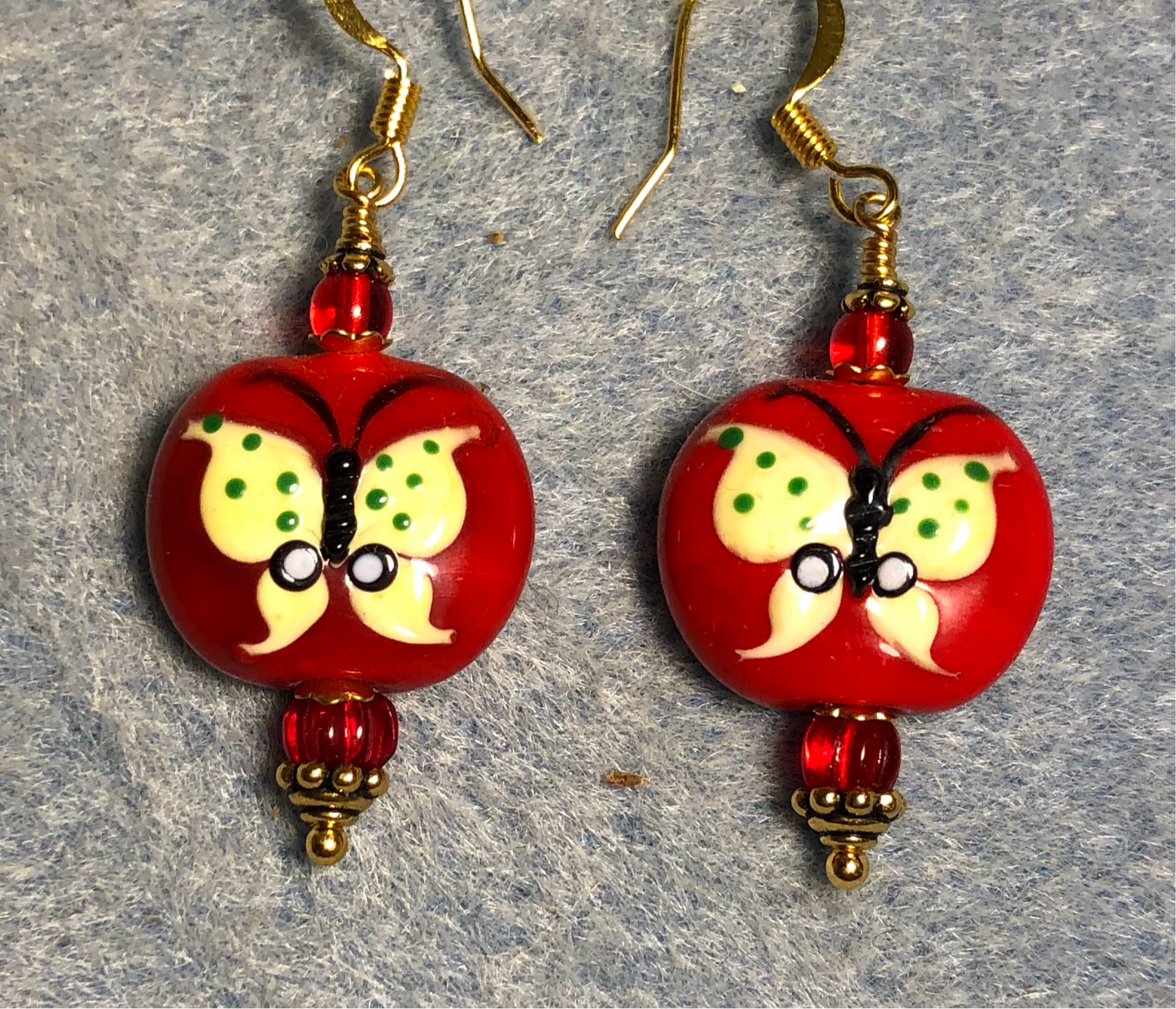 Red and yellow lamp work butterfly bead earrings adorned with red Czech glass beads.