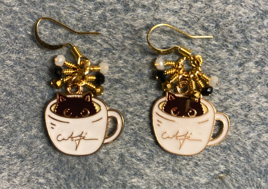 Black, white, and gold enamel cat charm earrings adorned with tiny dangling black, white, and gold Chinese crystal beads.