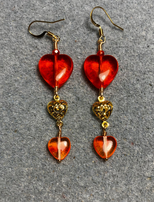Large and small matching orange Czech glass heart bead earrings joined by gold filigree heart connectors.