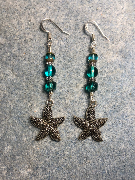 Silver starfish charm earrings adorned with turquoise Czech glass beads.