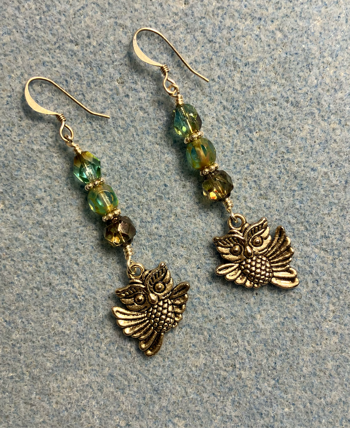 Silver owl charm earrings adorned with blue green Czech glass melon beads.