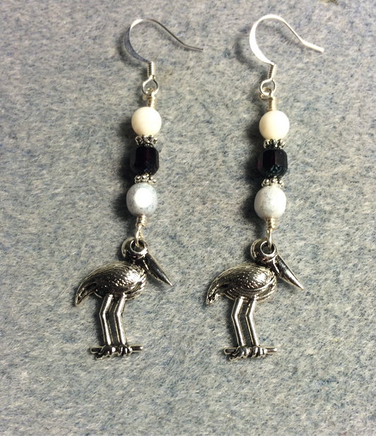 Silver stork charm earrings adorned with white and black Czech glass beads.