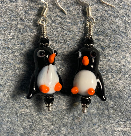 Black, white, and orange lamp work penguin bead earrings adorned with black Chinese crystal beads.