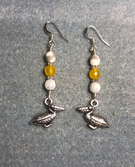 Silver pelican charm earrings adorned with white and amber Czech glass beads