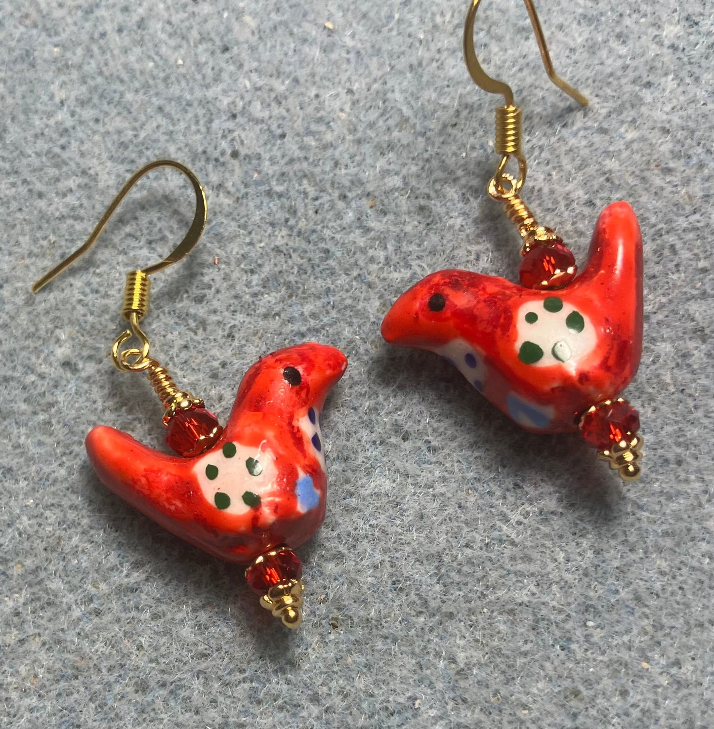 Small red, white, and black ceramic bird bead earrings adorned with red Chinese crystal beads.