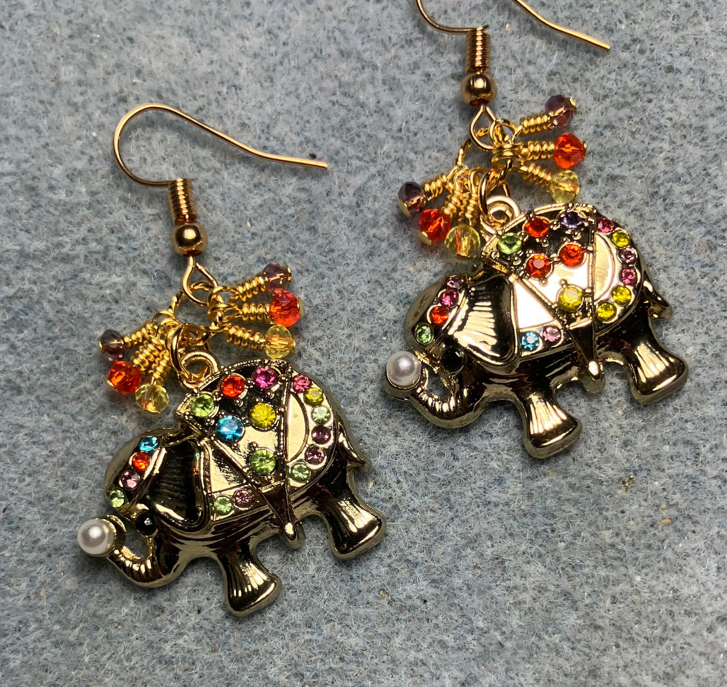 Large gold and multicolored rhinestone elephant charm earrings adorned with tiny dangling yellow, purple, and orange Chinese crystal beads.
