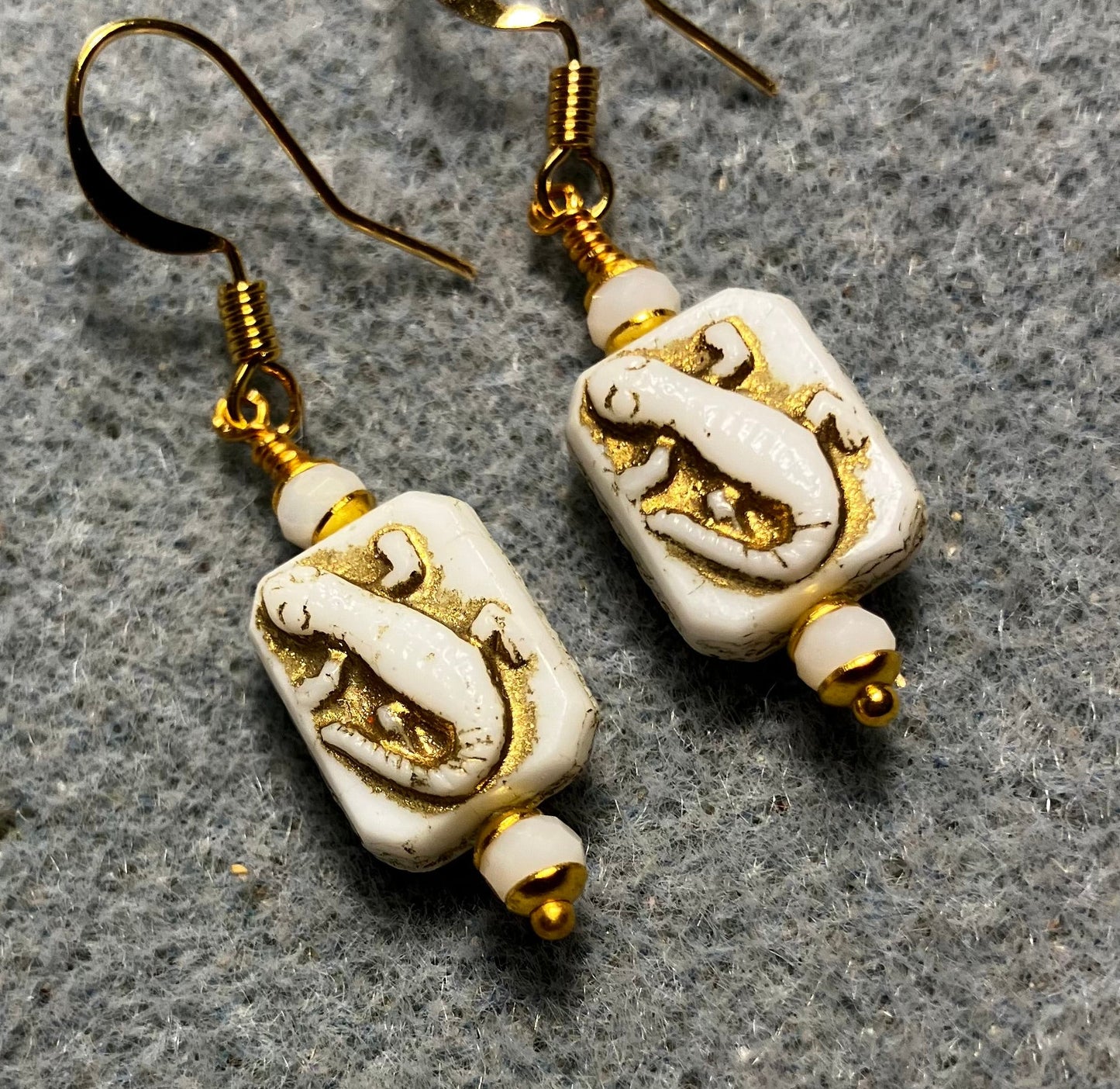 Small white and gold Czech glass lizard bead earrings adorned with white Chinese crystal beads.