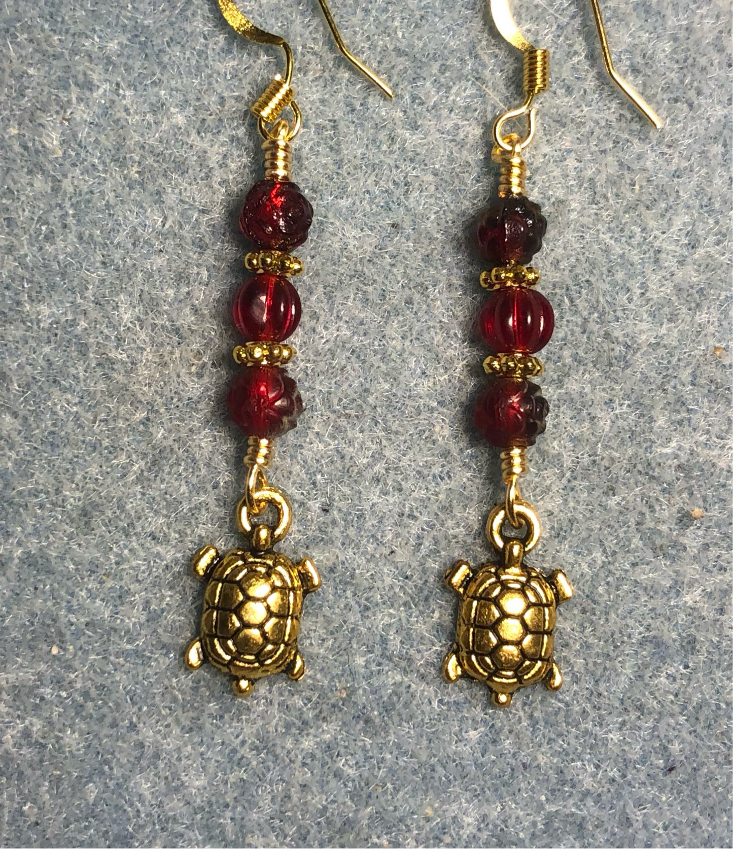 Small gold tortoise charm earrings adorned with small dark red Czech glass beads