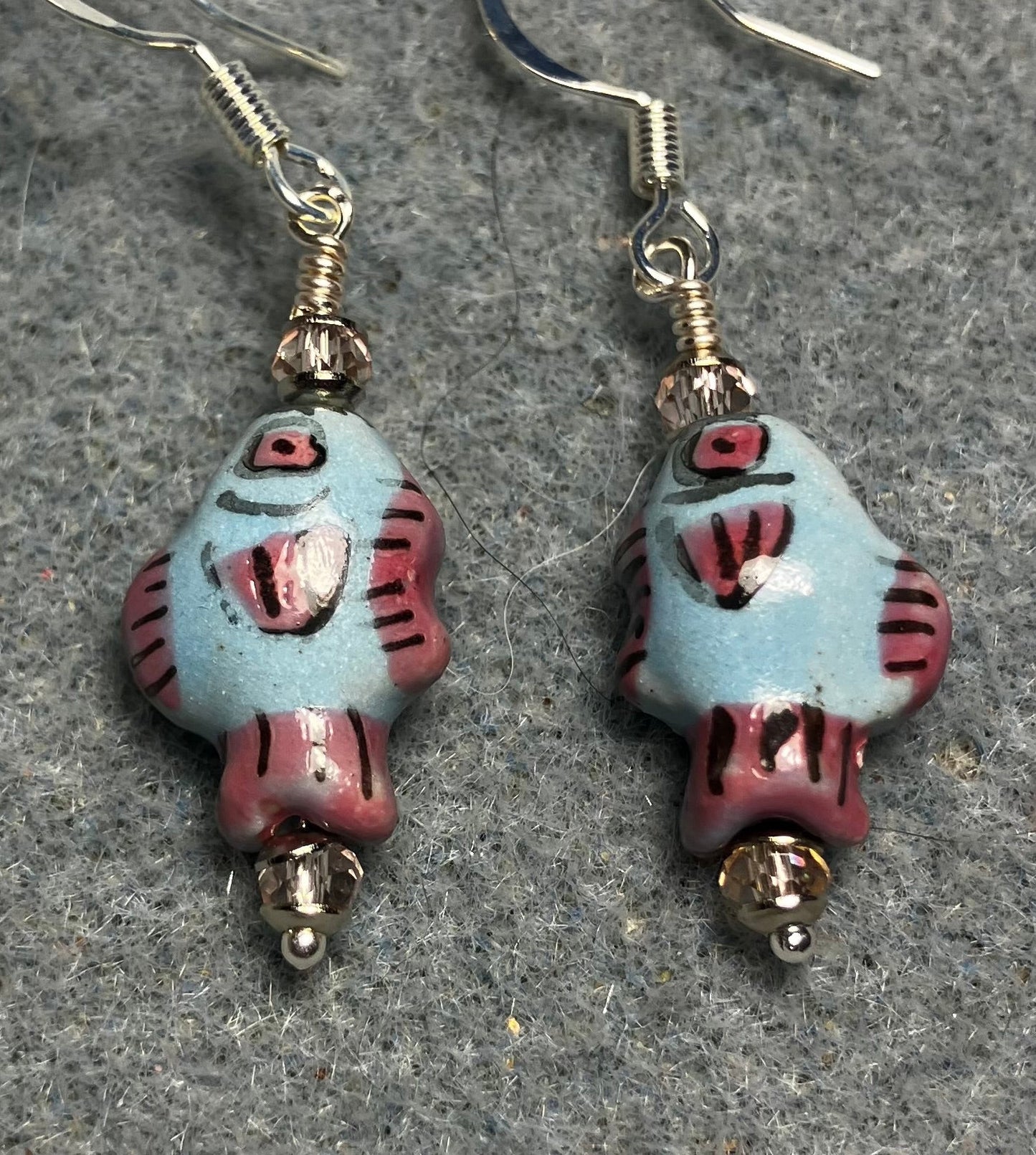 Small light blue, black, and pink ceramic fish bead earrings adorned with pink Chinese crystal beads.