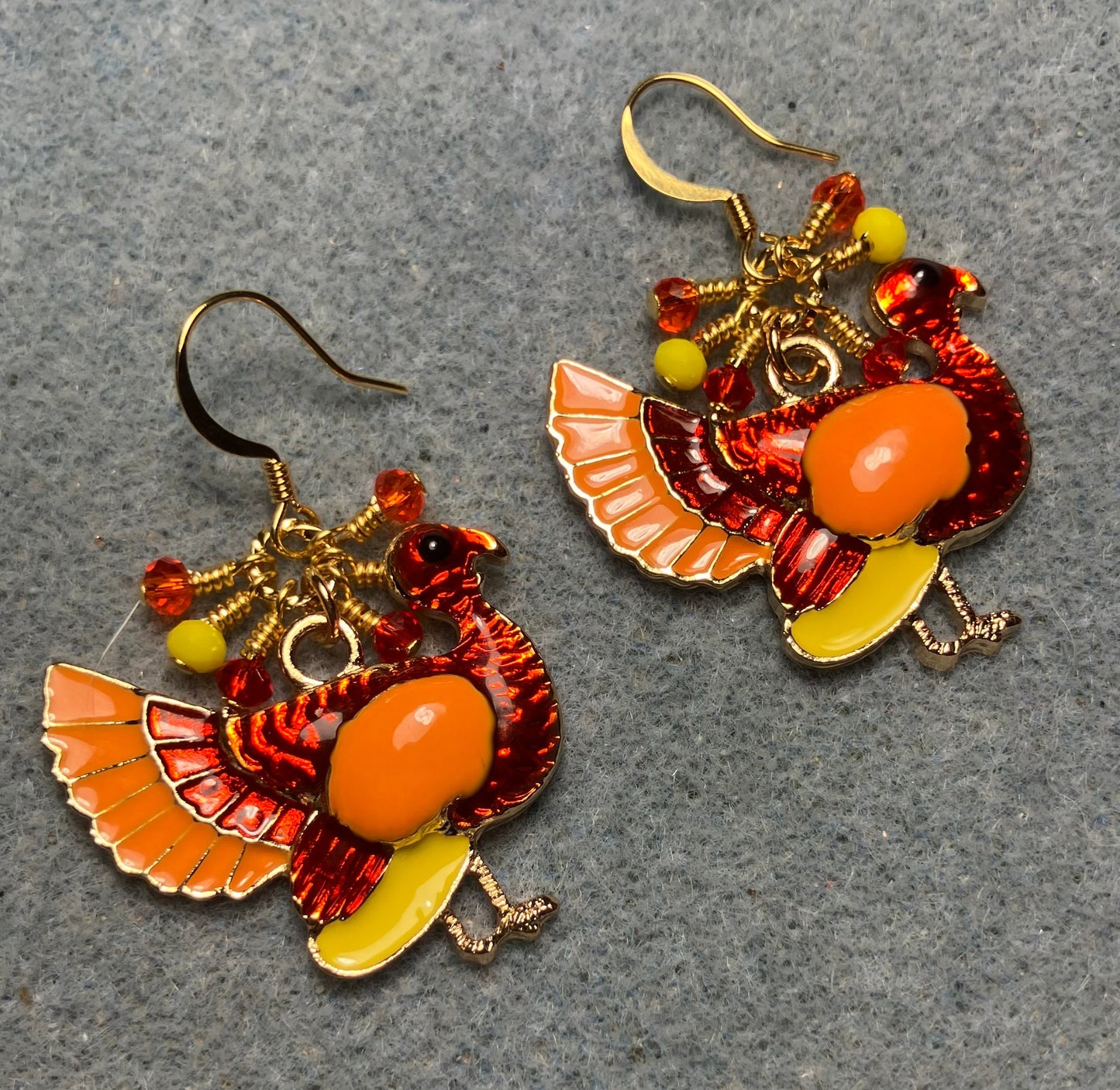 Red, orange, and yellow enamel turkey charm earrings adorned with small dangling red, orange, and yellow Chinese crystal beads.