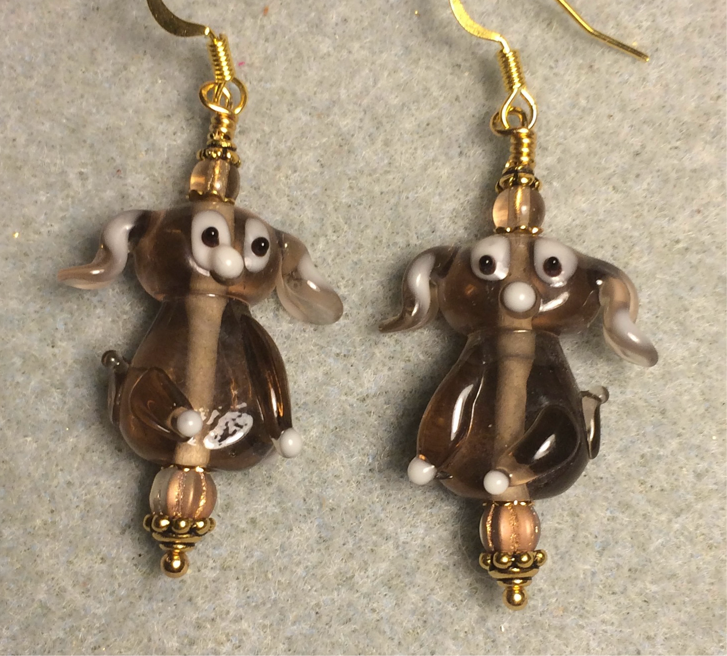 Translucent tan lamp work floppy eared puppy dog bead earrings adorned with tan Czech glass beads.