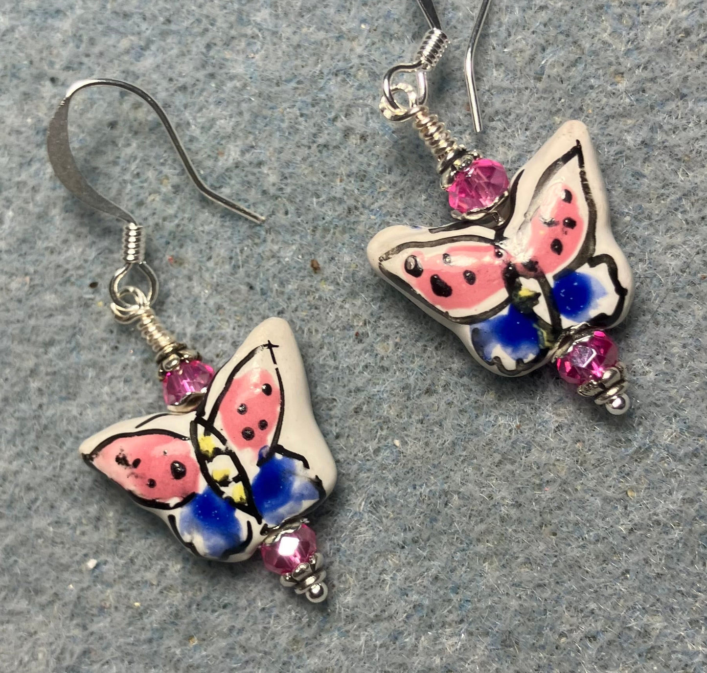 Hot pink and blue ceramic butterfly bead earrings adorned with hot pink Chinese crystal beads.